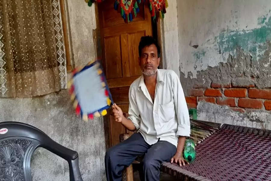 Hasim Khan fans himself to find respite from heat in the absence of electricity in Madarnagar village of Unnao district in Uttar Pradesh